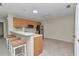 Bright kitchen features light wood cabinets, stainless steel appliances, and a casual bar seating area at 2608 Botello Ave, The Villages, FL 32162