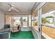 Bright sunroom features a ceiling fan, neutral tones, and comfortable seating and great outdoor view at 2608 Botello Ave, The Villages, FL 32162