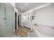 Large bathroom with dual sinks, granite counters, decorative shelving, soaking tub, and a glass enclosed shower at 2671 Sw 158Th Lane Rd, Ocala, FL 34473