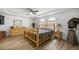Spacious bedroom featuring a rustic wood bed set, wood laminate flooring, and a lighted ceiling fan at 2671 Sw 158Th Lane Rd, Ocala, FL 34473