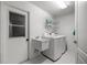 Bright laundry room with a utility sink, washer, dryer, and storage shelves at 2671 Sw 158Th Lane Rd, Ocala, FL 34473