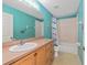 Bathroom features a vanity, shower over tub, and colorful turquoise walls at 30 Bahia Trace Loop, Ocala, FL 34472