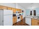 Bright kitchen features white appliances, wood cabinets and granite countertops at 30 Bahia Trace Loop, Ocala, FL 34472