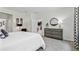 Bedroom with view to kitchen featuring a large bed, grey dresser, and ample natural light at 3066 Canopy Oak Blvd, Wildwood, FL 34785