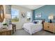 Cozy bedroom with charming decor, blue accent wall, and large windows overlooking the neighborhood at 3066 Canopy Oak Blvd, Wildwood, FL 34785