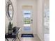 Bright foyer features a stylish mirror, a console table, and a view to the backyard at 3066 Canopy Oak Blvd, Wildwood, FL 34785