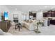 Open-concept living area with a modern kitchen, comfortable seating, and neutral colors at 3066 Canopy Oak Blvd, Wildwood, FL 34785