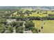 Aerial view showcasing a neighborhood next to green fields and mature trees at 4701 Nw 60Th Terrace, Ocala, FL 34482