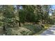 Landscaped front yard featuring lush greenery, mature trees, flowering shrubs, and a well-manicured lawn at 4701 Nw 60Th Terrace, Ocala, FL 34482