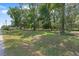 Spacious front yard featuring mature trees, green lawn, and street access, offering a welcoming curb appeal at 4701 Nw 60Th Terrace, Ocala, FL 34482