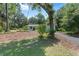 Landscaped single-story home featuring beautiful trees and a winding driveway at 4701 Nw 60Th Terrace, Ocala, FL 34482