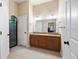 Bright bathroom featuring double vanity with granite countertops and tile flooring at 6235 Sw 95Th Pl, Ocala, FL 34476