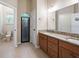 Bathroom featuring double sinks, granite countertops and a large mirror at 6235 Sw 95Th Pl, Ocala, FL 34476
