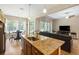 The kitchen with granite countertops connects to the living room with a ceiling fan and a couch at 6235 Sw 95Th Pl, Ocala, FL 34476