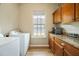 Well-equipped laundry room with wooden cabinets and granite countertops at 6235 Sw 95Th Pl, Ocala, FL 34476