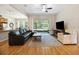 Bright and airy living room with hardwood floors, a ceiling fan, and a screened-in porch at 6235 Sw 95Th Pl, Ocala, FL 34476