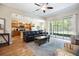Open-concept living space with hardwood floors and a view of the kitchen and screened lanai at 6235 Sw 95Th Pl, Ocala, FL 34476