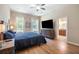 The main bedroom features a queen bed, bedside tables, and an entertainment center with television at 6235 Sw 95Th Pl, Ocala, FL 34476