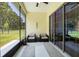 Enclosed patio with neutral decor and view of a grassy backyard at 6235 Sw 95Th Pl, Ocala, FL 34476