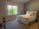 Stylish bedroom with a modern bed, neutral tones, large window with outdoor views, and elegant wooden accents at 6925 Nw Highway 225A, Ocala, FL 34482
