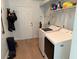 Bright laundry room featuring modern washer and dryer, storage shelf, and convenient access to the exterior at 6925 Nw Highway 225A, Ocala, FL 34482