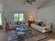 Bright living room with two white sofas, modern rug, and large window offering natural light at 6925 Nw Highway 225A, Ocala, FL 34482