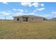 Rear view of the home showing the expansive lawn and slider doors to enter the residence at 7 Walnut Pl, Ocala, FL 34480