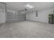 Spacious garage featuring a gray door, concrete flooring, and block walls, providing ample storage and parking at 7 Walnut Pl, Ocala, FL 34480