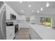 A bright kitchen features stainless steel appliances, white countertops, and an extended island with backyard access at 7 Walnut Pl, Ocala, FL 34480
