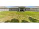 Expansive backyard featuring a well-maintained lawn, gray privacy fence and covered patio area at 7442 Sw 129Th Ln, Ocala, FL 34473