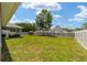 Spacious backyard featuring a well-manicured lawn, privacy fence, and a covered patio area at 7442 Sw 129Th Ln, Ocala, FL 34473