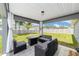 Relaxing covered patio with stylish outdoor furniture overlooking the lush, fenced backyard at 7442 Sw 129Th Ln, Ocala, FL 34473