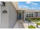 Inviting front entrance with a blue door and well-kept landscaping at 7442 Sw 129Th Ln, Ocala, FL 34473