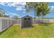 Backyard storage shed for all your lawn and garden equipment; surrounded by green grass and a gray privacy fence at 7442 Sw 129Th Ln, Ocala, FL 34473