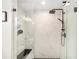 Elegant walk-in shower featuring marble-look tile, rainfall shower head, and a built-in bench at 7442 Sw 129Th Ln, Ocala, FL 34473