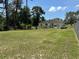 Expansive backyard featuring lush lawn, garden beds, mature trees, and a charming single-story home beyond at 7800 Sw 127Th Loop, Ocala, FL 34473