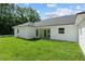 Backyard view of the home with a covered patio and green grass surrounded by lush trees at 8293 Se 158Th St, Summerfield, FL 34491