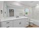 Bathroom showcasing large mirror, white cabinetry, dual sinks, marble style shower and modern fixtures at 8293 Se 158Th St, Summerfield, FL 34491