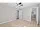 Bedroom with plush carpeting and neutral walls, featuring a ceiling fan and walk-in closet at 8293 Se 158Th St, Summerfield, FL 34491