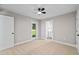 A carpeted bedroom is illuminated by a ceiling fan and includes a door to the backyard at 8293 Se 158Th St, Summerfield, FL 34491