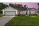Charming single-story home with a well-manicured lawn and black trimmed windows at 8293 Se 158Th St, Summerfield, FL 34491