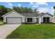 Charming single-story home featuring a two-car garage and well-manicured lawn at 8293 Se 158Th St, Summerfield, FL 34491
