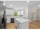 Bright and modern kitchen features a kitchen island, white cabinets and stainless steel appliances at 8293 Se 158Th St, Summerfield, FL 34491