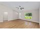 Open living area with a large window, modern ceiling fan, and adjacent doorway at 8293 Se 158Th St, Summerfield, FL 34491