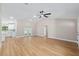 Open-concept living room features a ceiling fan, wood floors, and natural light at 8293 Se 158Th St, Summerfield, FL 34491
