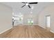 Spacious living room with wood floors and white kitchen in background at 8293 Se 158Th St, Summerfield, FL 34491