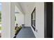 Under the porch overlooking landscaping and black trimmed windows at 8293 Se 158Th St, Summerfield, FL 34491
