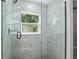 Modern glass shower with a window and attractive gray-and-white marble-patterned tile surround at 8293 Se 158Th St, Summerfield, FL 34491