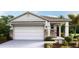 Charming single-story home featuring stone accents, a two-car garage, and nicely landscaped front yard at 8577 Pinecrest Trl, Wildwood, FL 34785