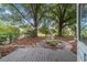 View of the backyard featuring mature trees, wood deck and small landscaping at 9001 Sw 91St Cir, Ocala, FL 34481